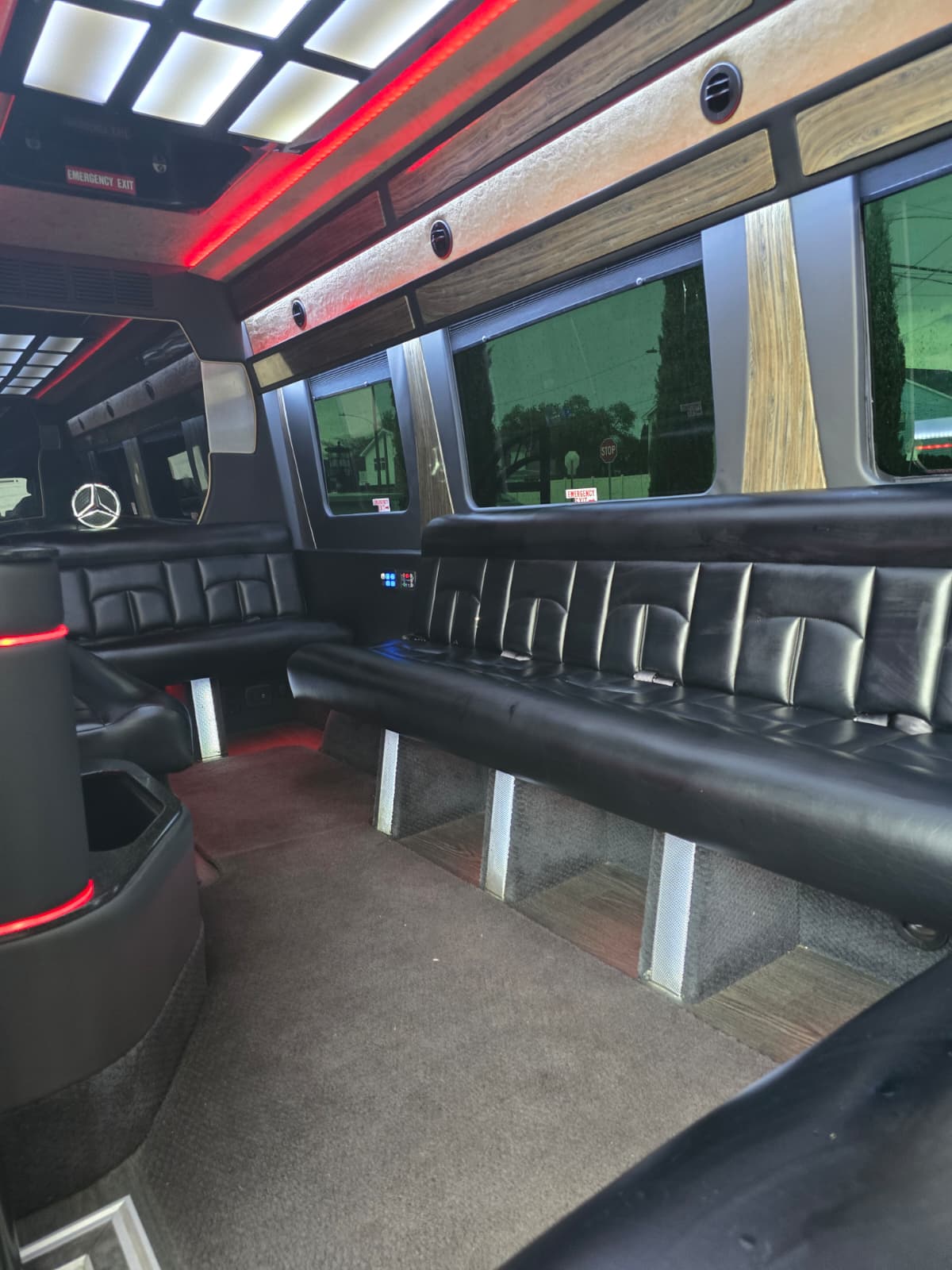 Party bus interior with red ambient lighting and tufted leather benches