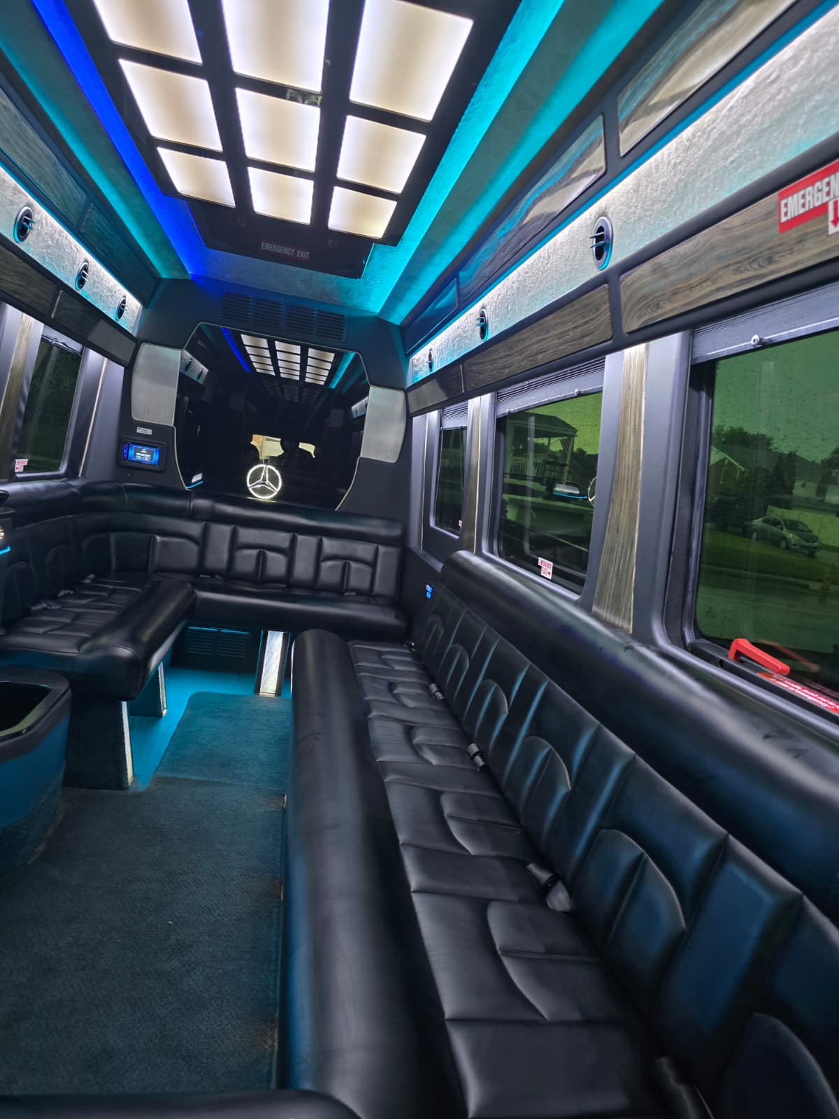 Party bus interior glowing teal with wraparound leather lounge